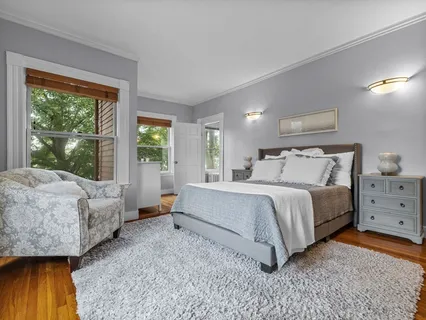 a spacious bedroom with a bed and wooden floor