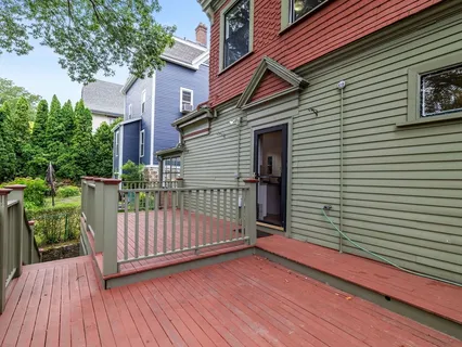 a balcony with wooden floor and yard in the back