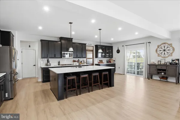a large kitchen with stainless steel appliances a sink a stove and a wooden floors