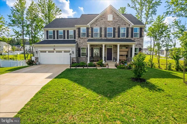 a front view of a house with a yard and trees