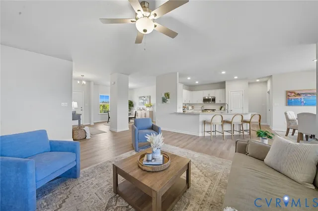 a kitchen with stainless steel appliances granite countertop a stove top oven a sink dishwasher and white cabinets with wooden floor