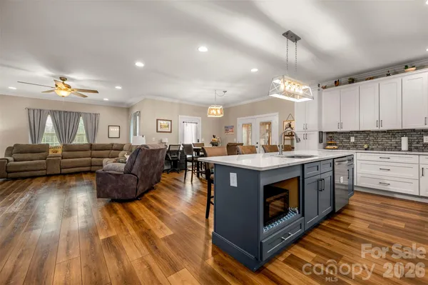 a large kitchen with stainless steel appliances granite countertop a stove and a wooden floors
