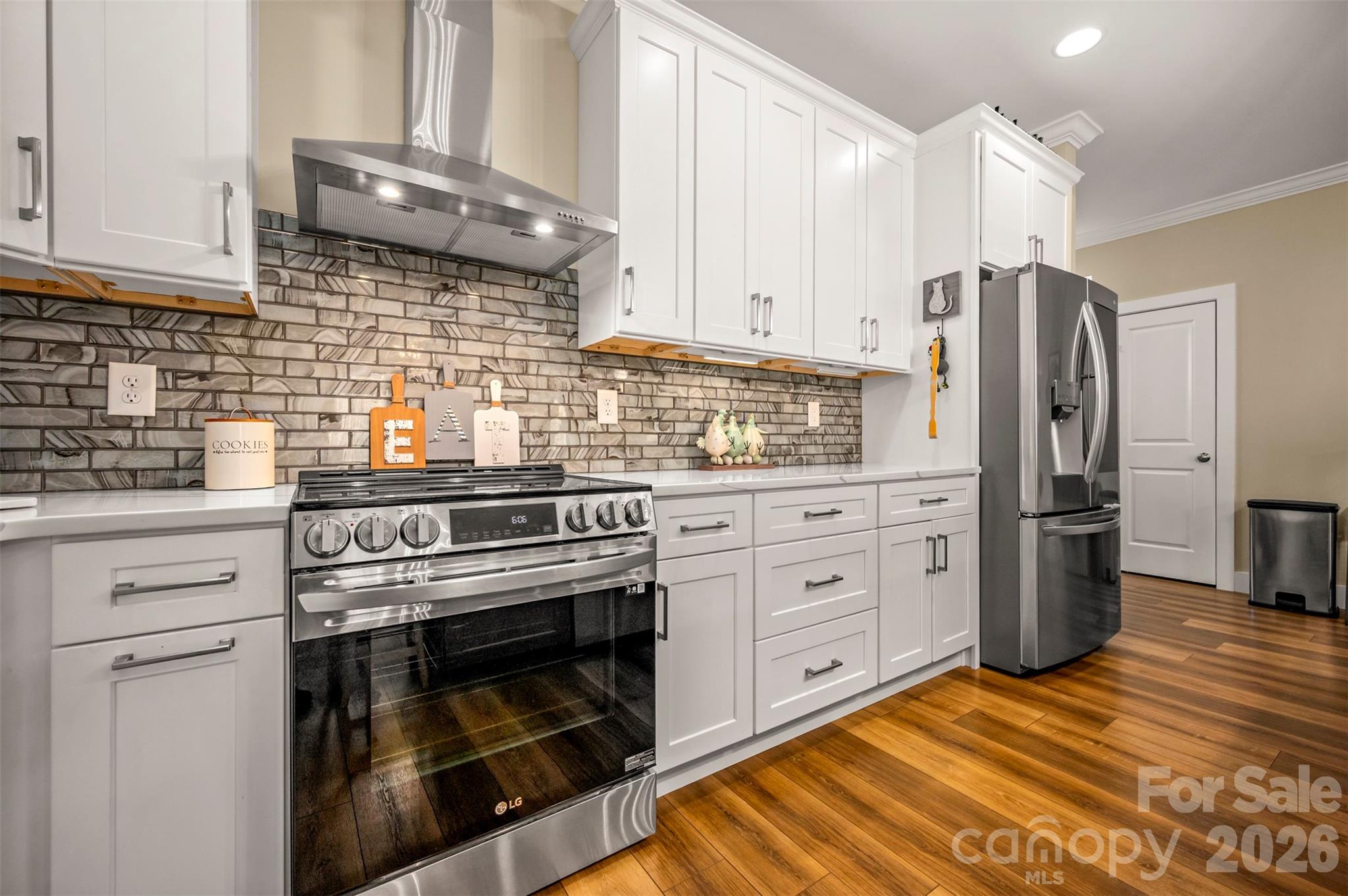 457 Edwards Street Extension Rutherfordton, NC 28139 - Photo 6 of 39 a kitchen with stainless steel appliances white cabinets and a stove top oven