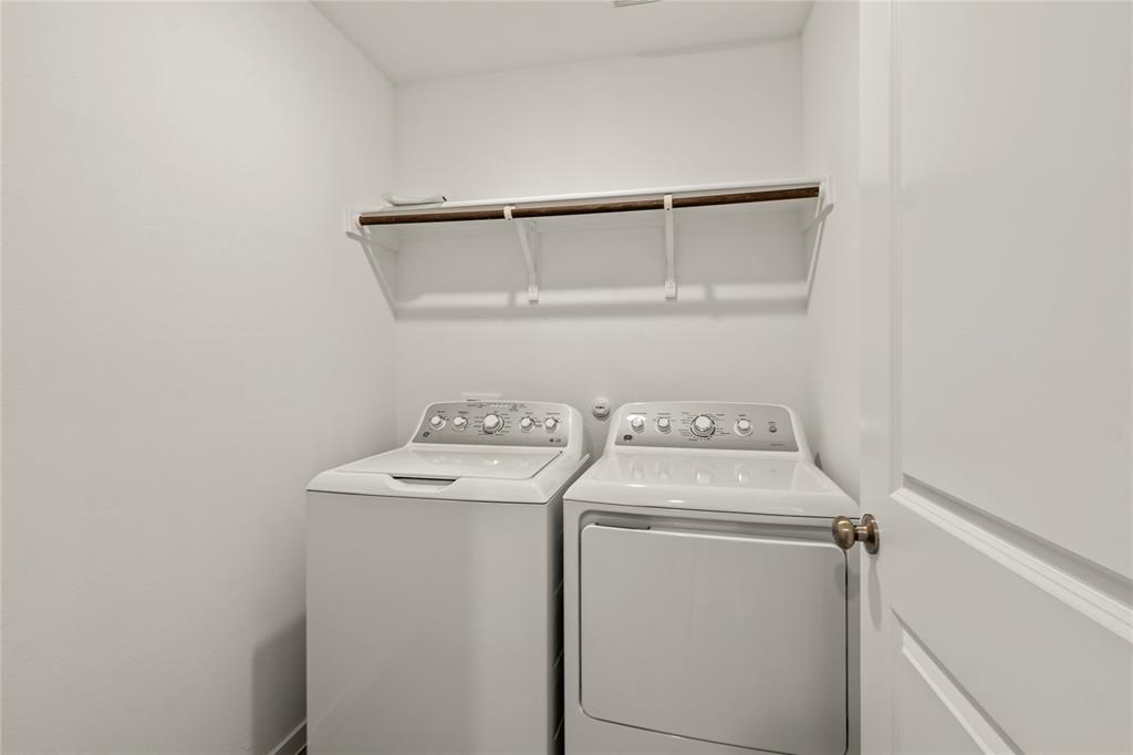 1138 Barbary Flds Street Forney, TX 75126 - Photo 17 of 25 Dedicated laundry space featuring a white top-load washer, a white front-load dryer, and an overhead shelving unit with a hanging rod