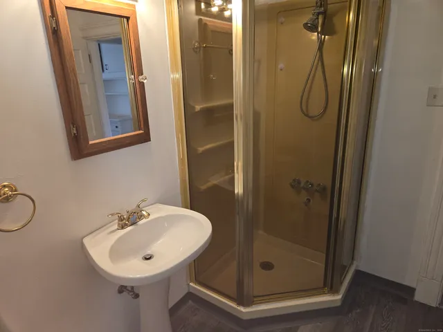 a bathroom with a sink mirror and shower