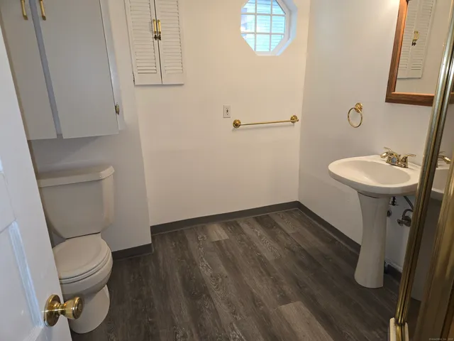 a bathroom with a toilet a sink and mirror
