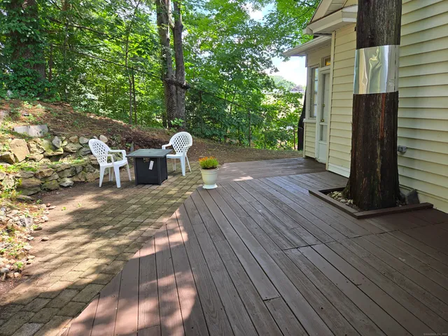 a view of a patio with table and chairs with wooden floor and fence