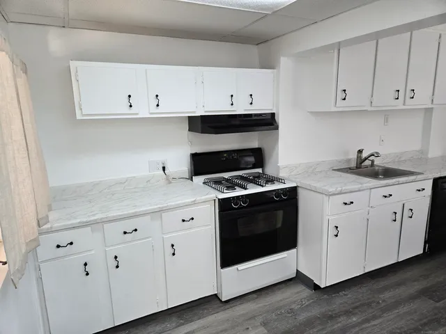 a kitchen with white cabinets and white appliances