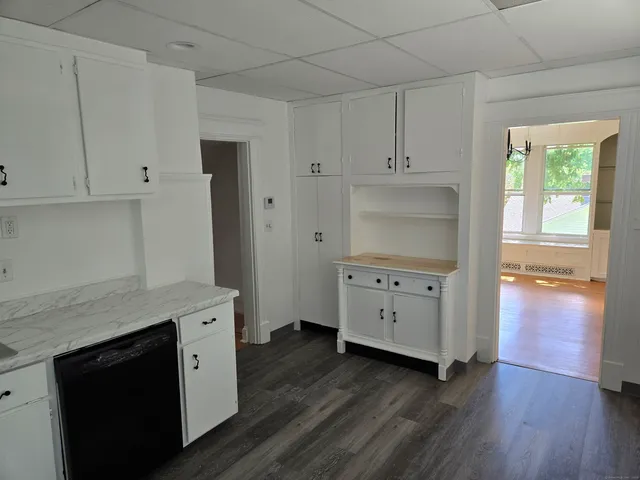 a kitchen with cabinets wooden floor and a fireplace