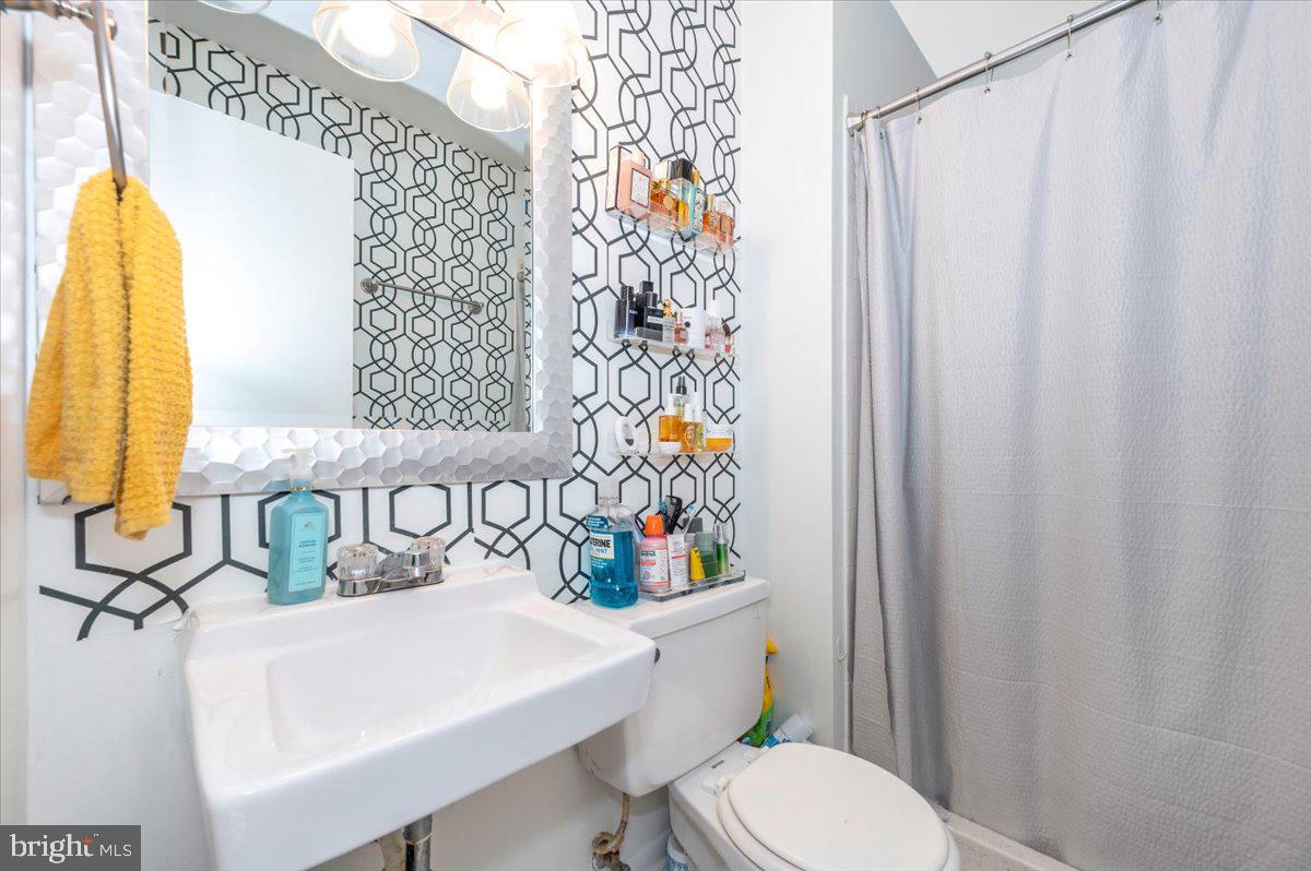 8826 Stauffer Road Walkersville, MD 21793 - Photo 26 of 38 a bathroom with a sink a toilet and a shower curtain