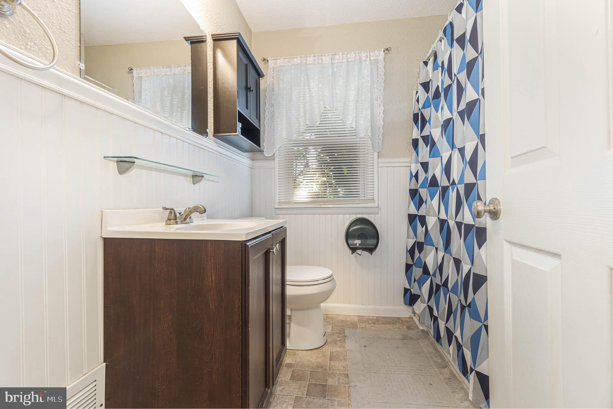 404 Beaumont Road York, PA 17403 - Photo 14 of 26 a bathroom with a sink a toilet and shower curtain
