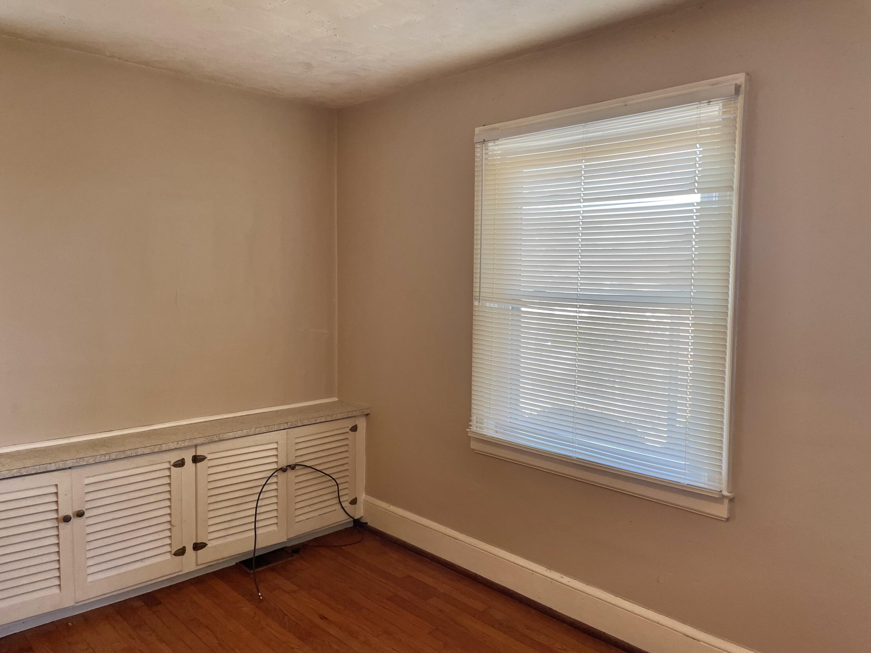 1152 Hamilton Avenue Southwest Roanoke, VA 24015 - Photo 13 of 36 a view of an empty room with wooden floor and a window