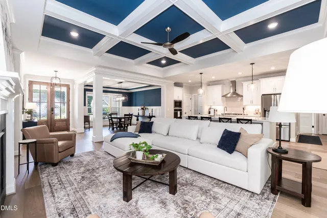 a living room with furniture kitchen view and a large window