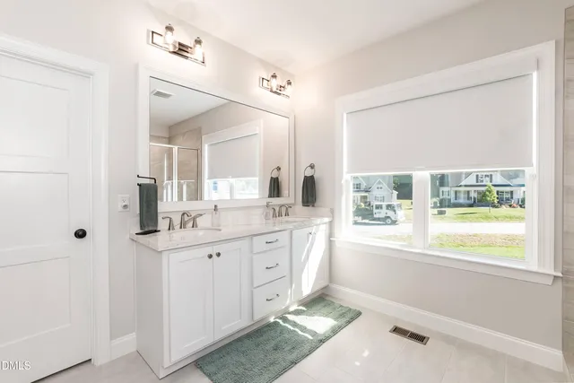a bathroom with a granite countertop sink a toilet and a large mirror
