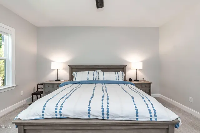 a bed sitting in a bedroom next to a window