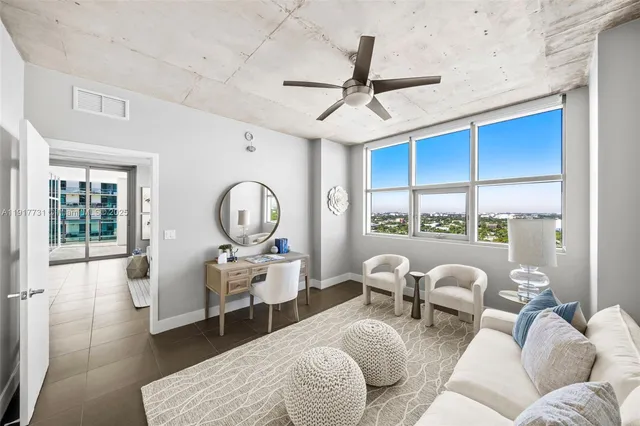 a living room with furniture a fireplace and a large window