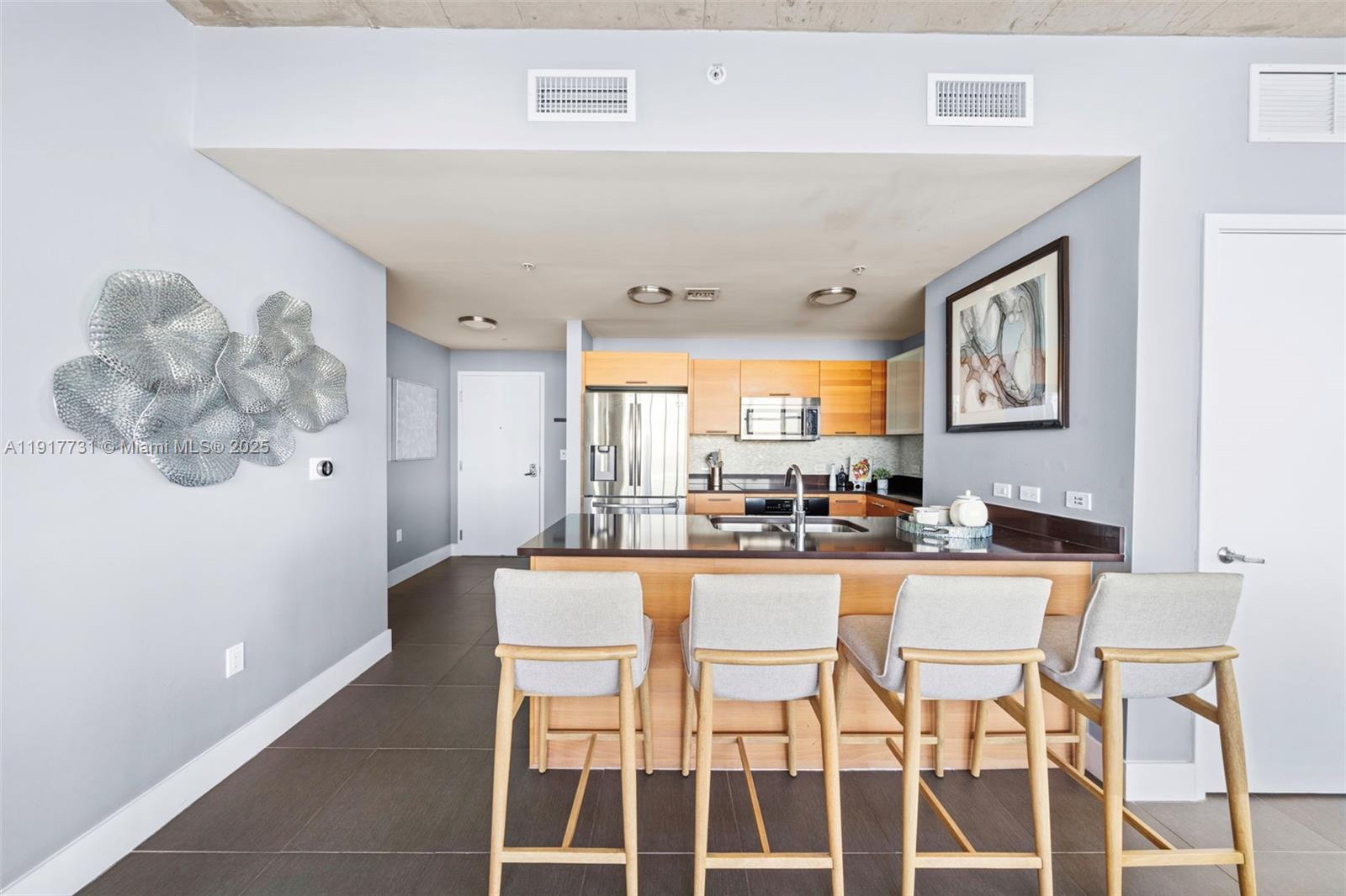 3301 Northeast 1st Avenue, Unit H2201 Miami, FL 33137 - Photo 2 of 46 a kitchen with a dining table chairs cabinets and stainless steel appliances