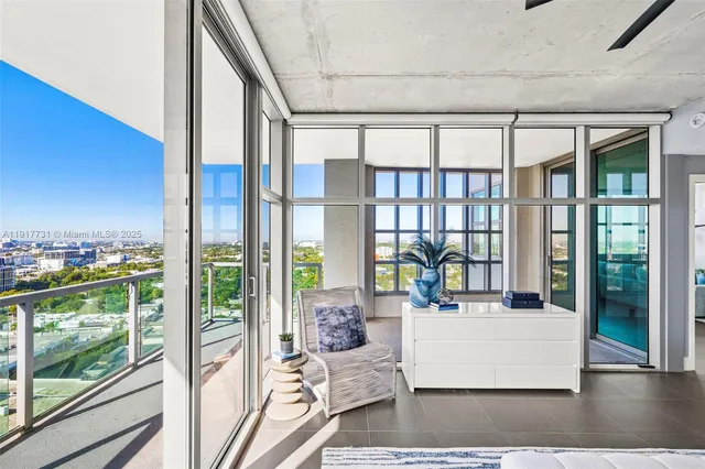 a living room with large windows and furniture