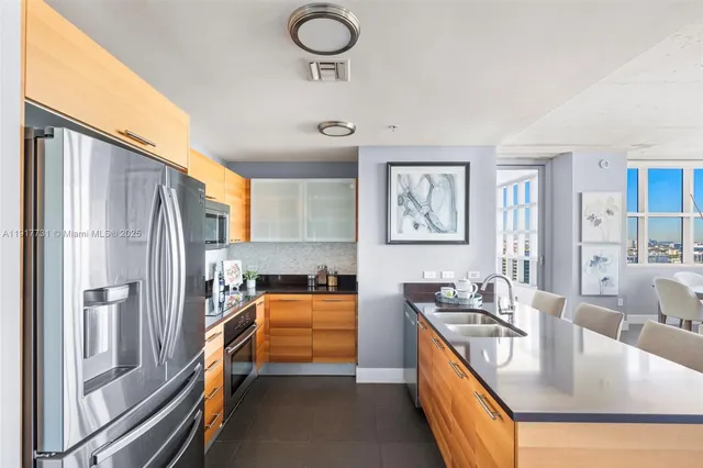 a kitchen with stainless steel appliances granite countertop a sink stove and refrigerator