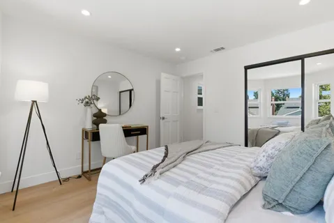 a bedroom with a bed and a mirror