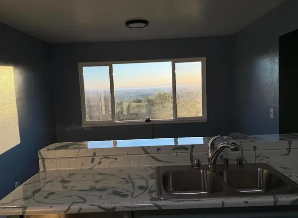 a kitchen with granite countertop white cabinets and white stove