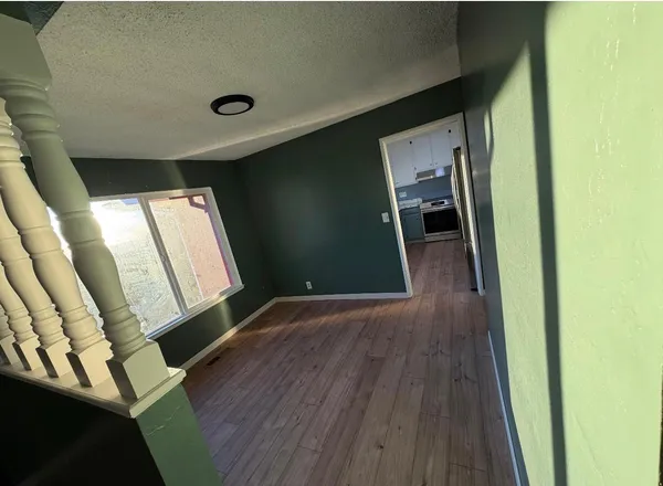 a view of a hallway with wooden floor and staircase