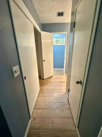 an empty room with wooden floor and entrance