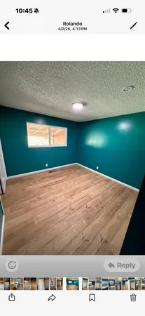 a view of empty room with window and wooden floor