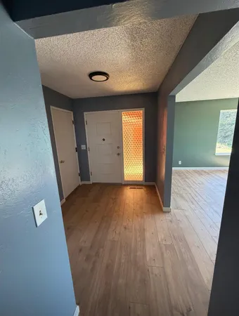 a view of a hallway with wooden floor and staircase