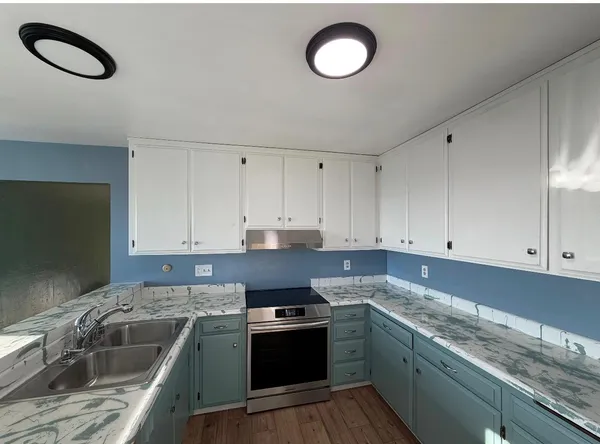 a bathroom with a granite countertop sink and a large mirror