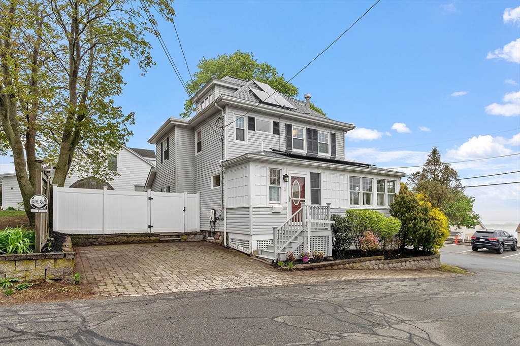 a white house that has a tree in front of it