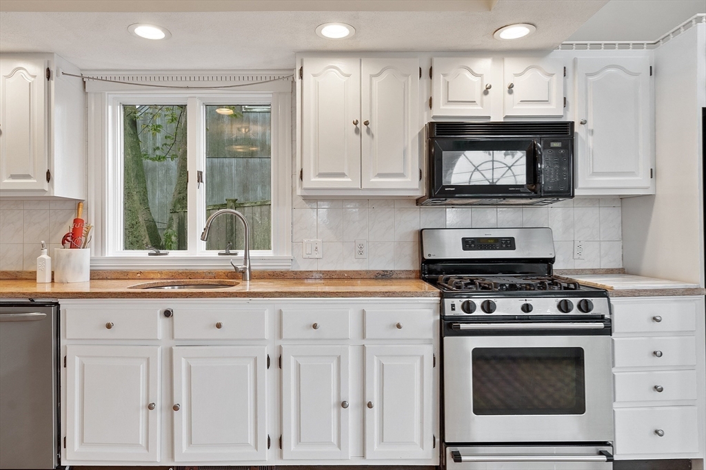 3 Baker Road Nahant, MA 01908 - Photo 9 of 41 a kitchen with white cabinets and appliances