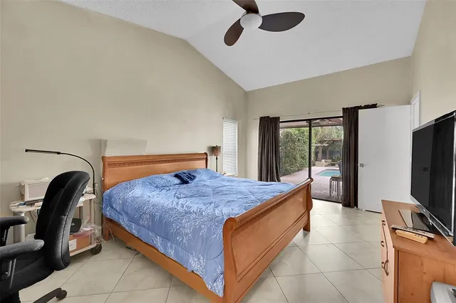a bedroom with a bed and a flat tv screen on the dresser