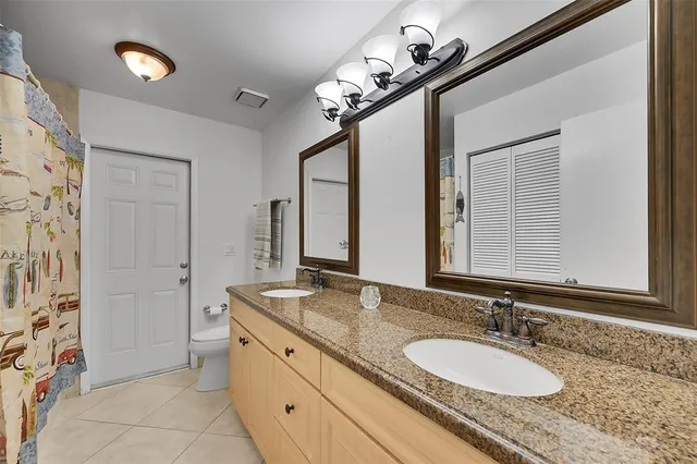 a bathroom with a granite countertop sink a mirror and a shower