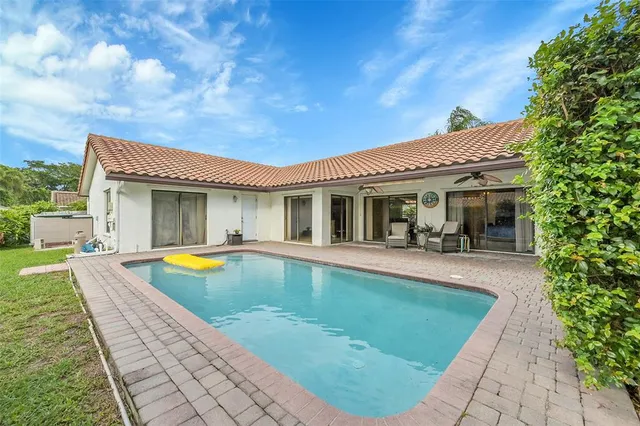 a view of a house with swimming pool and sitting area