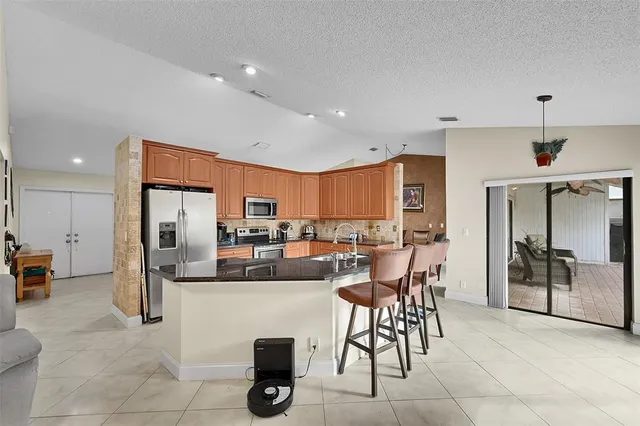 a dining hall with stainless steel appliances a dining table and chairs