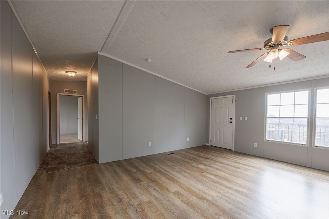 540 Wine Road Elizabeth, WV 26143 - Photo 20 of 49 Spare room with crown molding, wood finished floors, a textured ceiling, and a ceiling fan