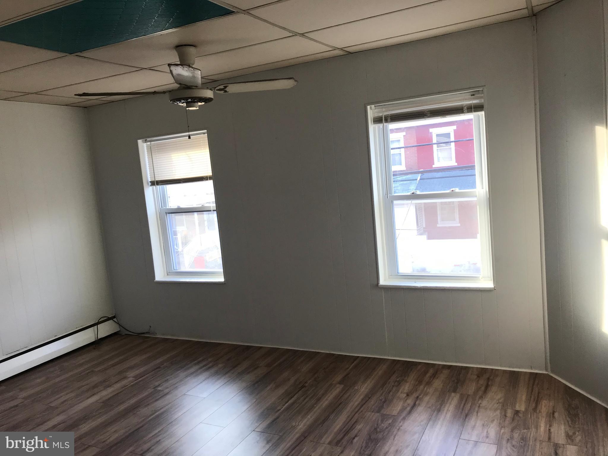 27 Upland Avenue Brookhaven, PA 19015 - Photo 7 of 8 an empty room with wooden floor fan and windows