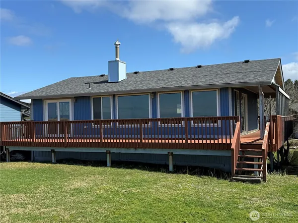 a view of a house with a deck and a yard
