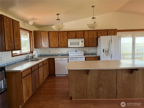a kitchen with kitchen island a sink a center island stainless steel appliances and a window