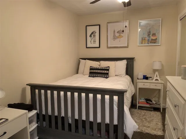 a bedroom with a bed and painting on the wall