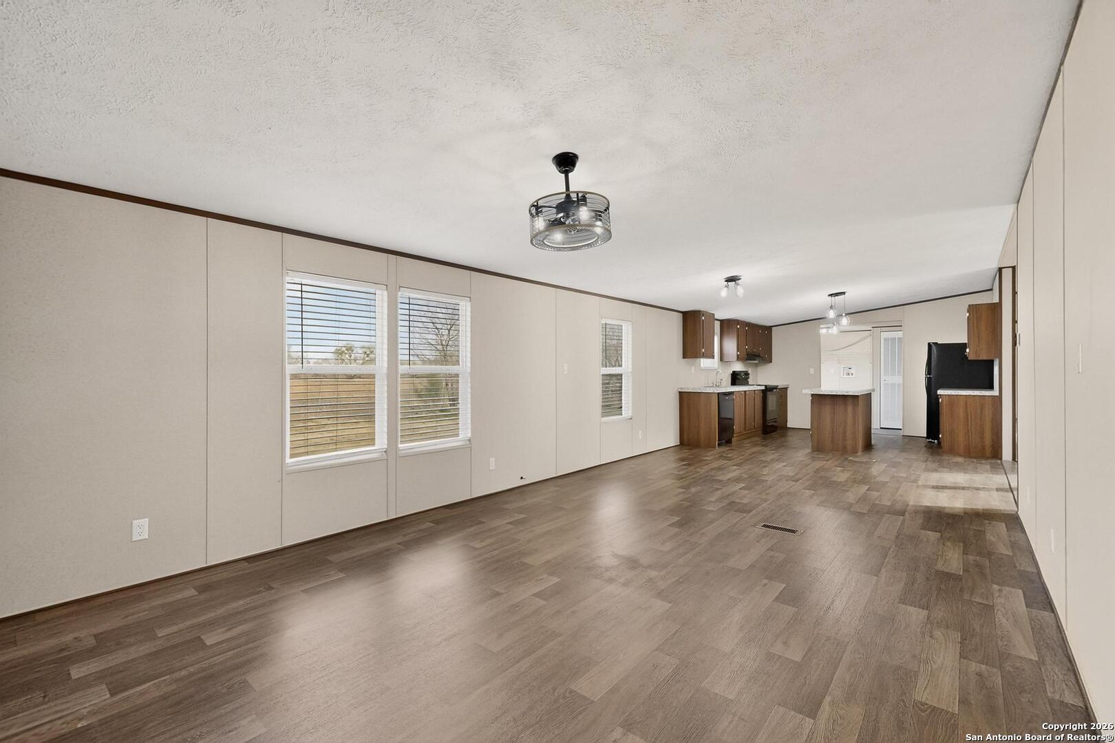 19124 La Gloria Road Elmendorf, TX 78112 - Photo 12 of 45 a view of empty room with wooden floor and window