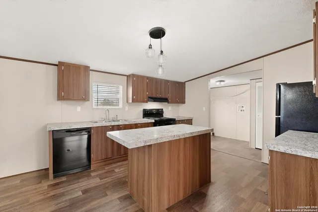 a kitchen with a sink a stove a refrigerator and cabinets