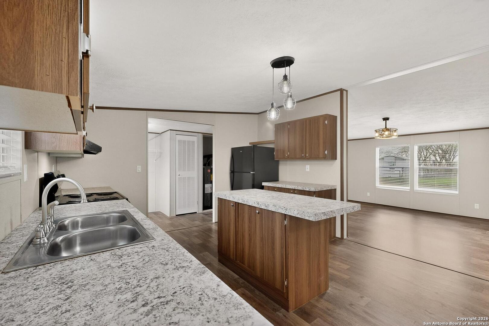 19124 La Gloria Road Elmendorf, TX 78112 - Photo 14 of 45 a kitchen with stainless steel appliances granite countertop a sink stove and refrigerator