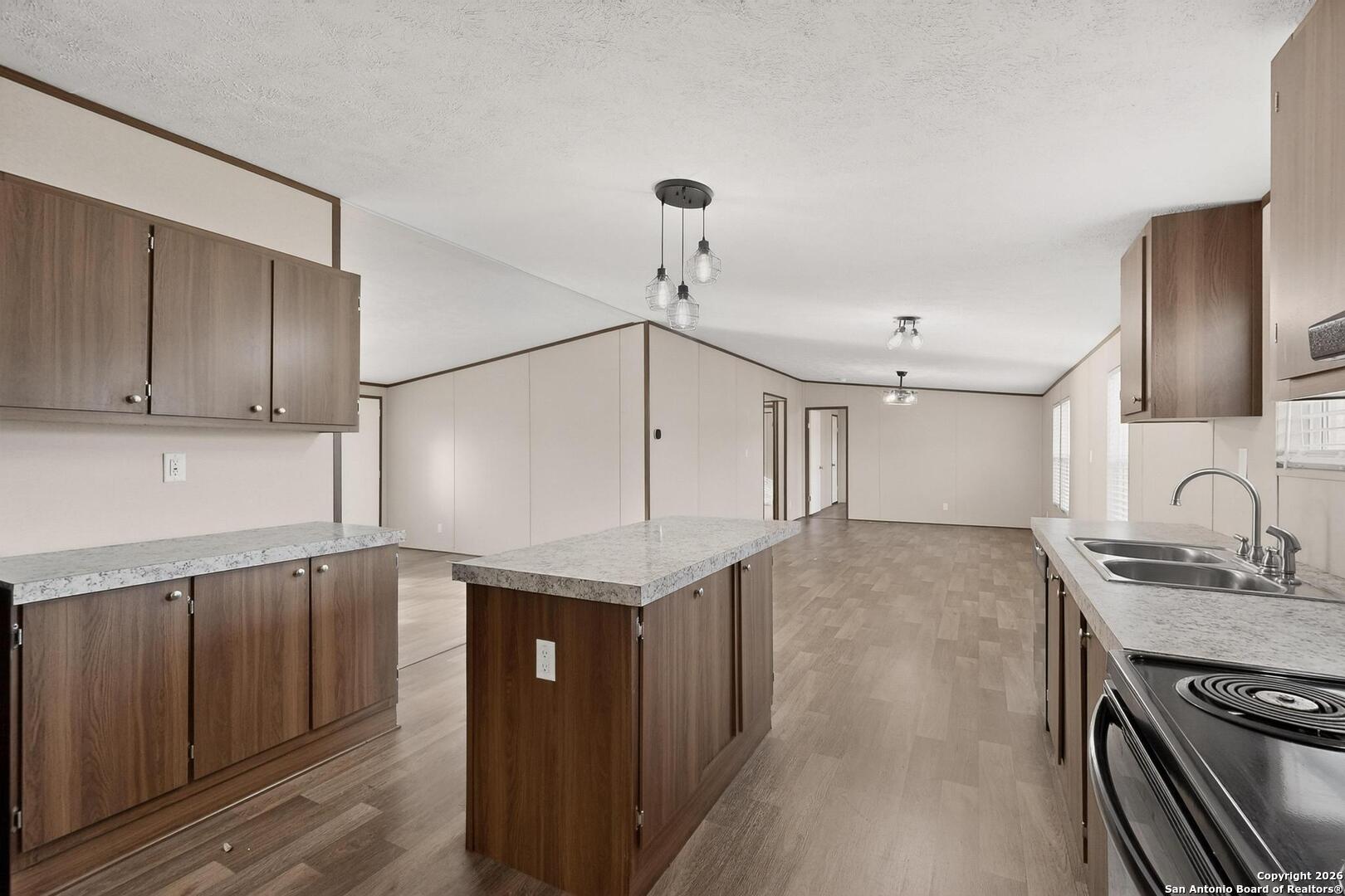 19124 La Gloria Road Elmendorf, TX 78112 - Photo 15 of 45 a kitchen with granite countertop a sink cabinets and wooden floor