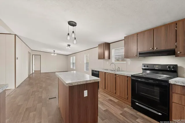 a kitchen with stainless steel appliances granite countertop a sink stove and cabinets