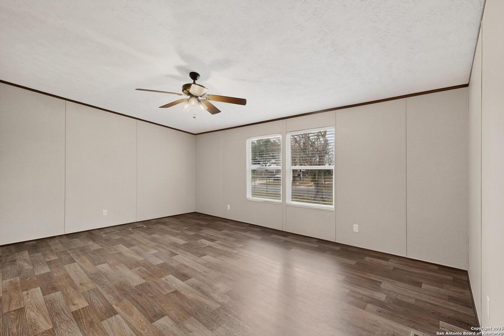 19124 La Gloria Road Elmendorf, TX 78112 - Photo 18 of 45 an empty room with chandelier fan and windows