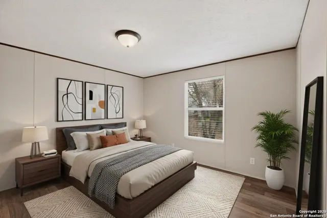 a bedroom with a large bed and a potted plant