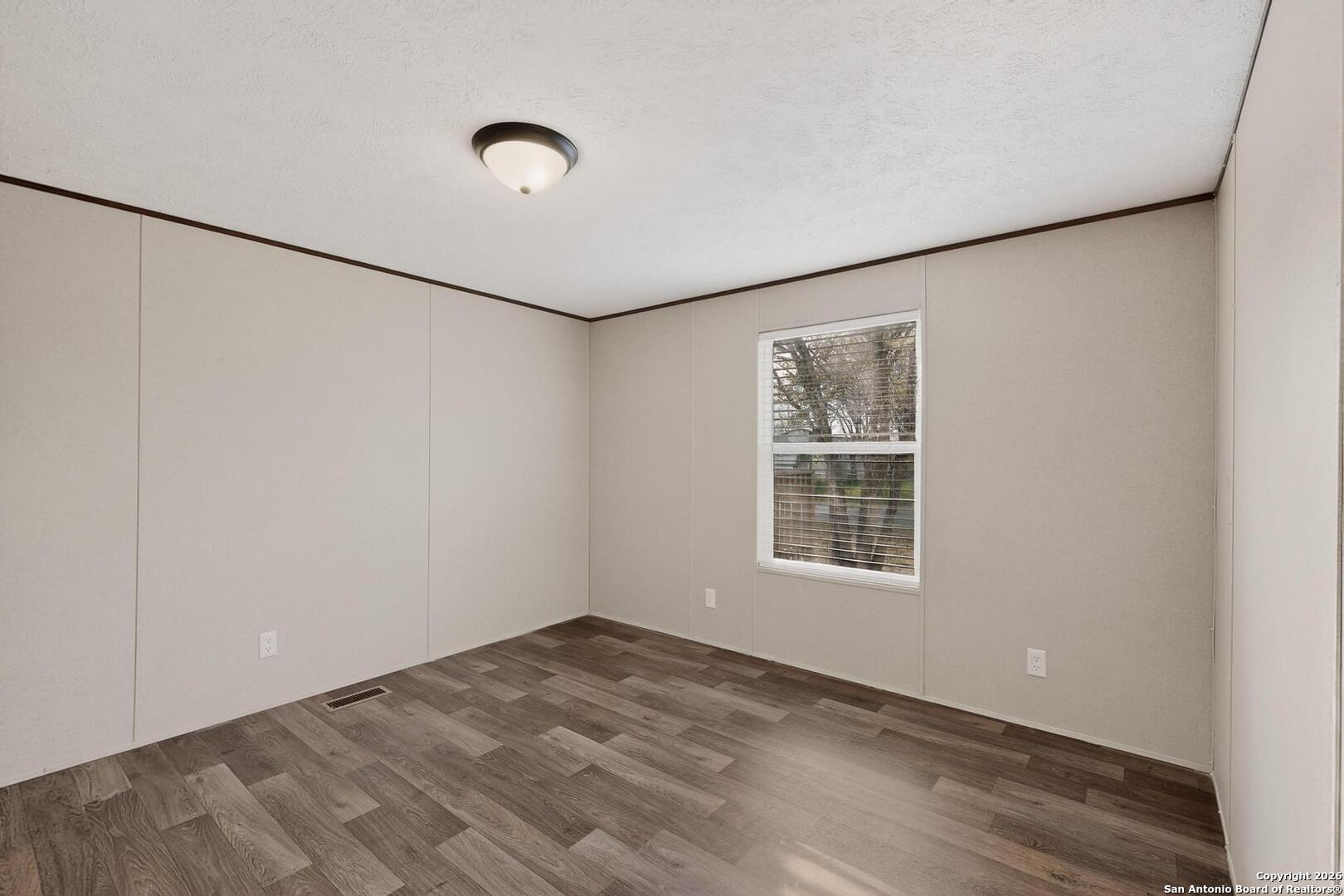 19124 La Gloria Road Elmendorf, TX 78112 - Photo 24 of 45 a view of a big room with wooden floor and windows