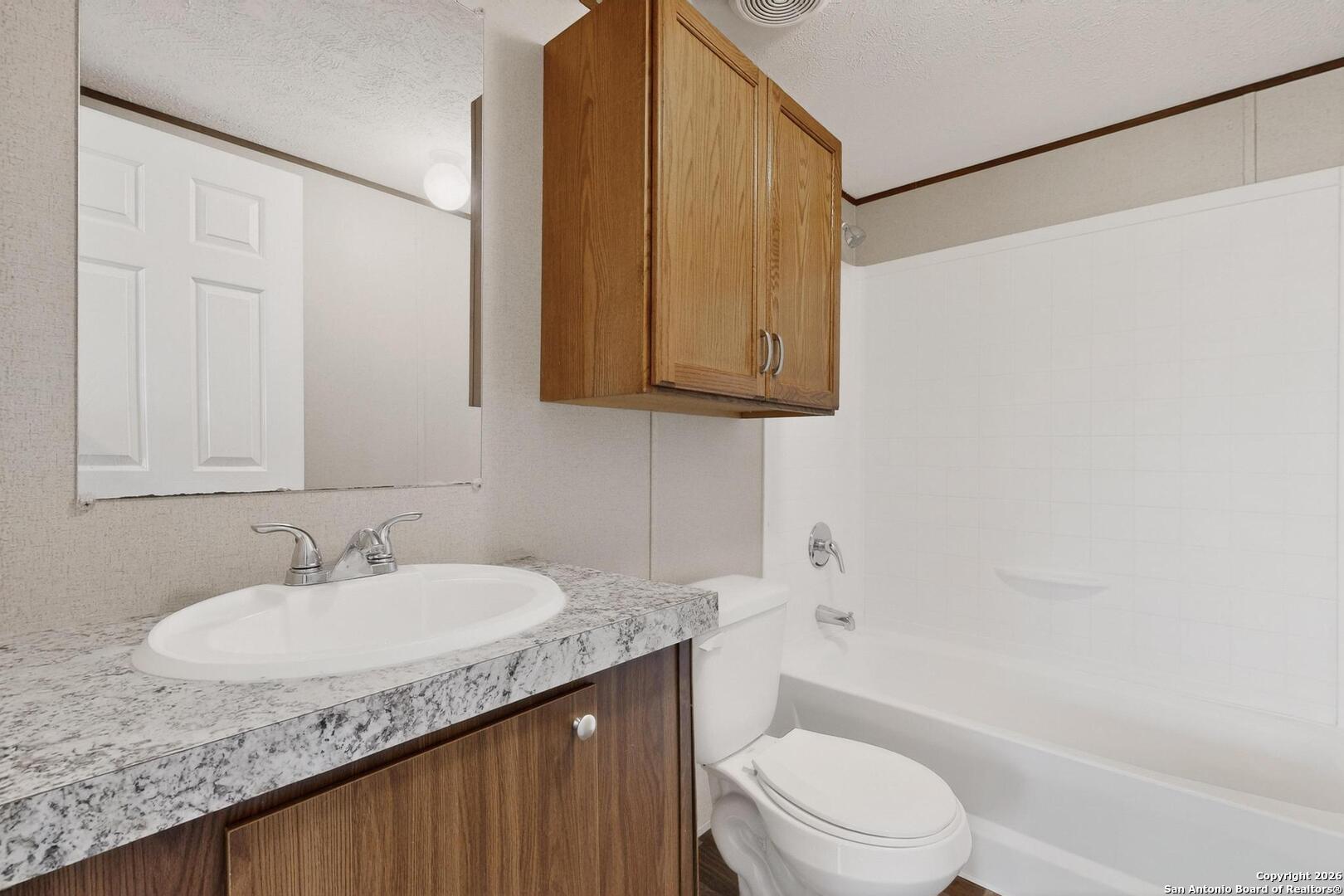 19124 La Gloria Road Elmendorf, TX 78112 - Photo 25 of 45 a bathroom with a granite countertop sink toilet and shower